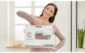 Woman smiling and holding the Brother SH40 electronic sewing machine