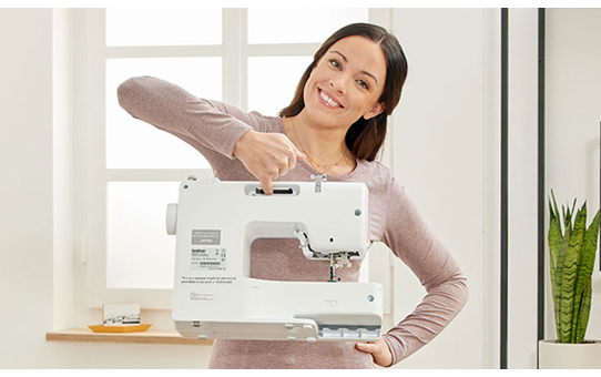 Woman smiling and holding the Brother SH40 electronic sewing machine