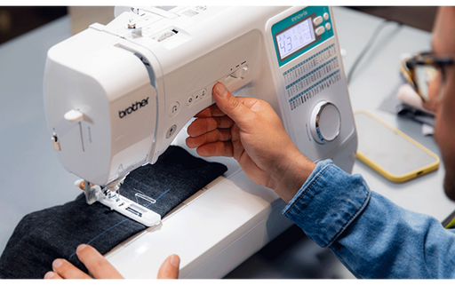 Person sewing denim fabric on the Brother Innov-is A65 sewing machine