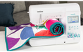 Brother Innov-is F560 sewing machine with colourful quilt on table