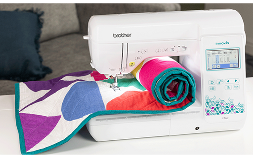 Brother Innov-is F560 sewing machine with colourful quilt on table