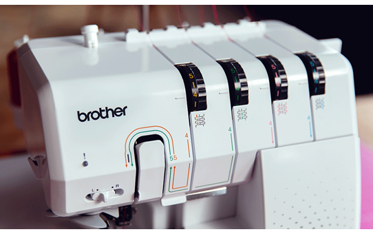 Close-up of the Brother Airflow 3000 overlocker showing colour-coded threading guides and tension dials