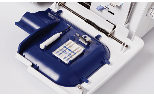 Open accessory compartment of the Brother 4234D overlocker showing needle set and accessories