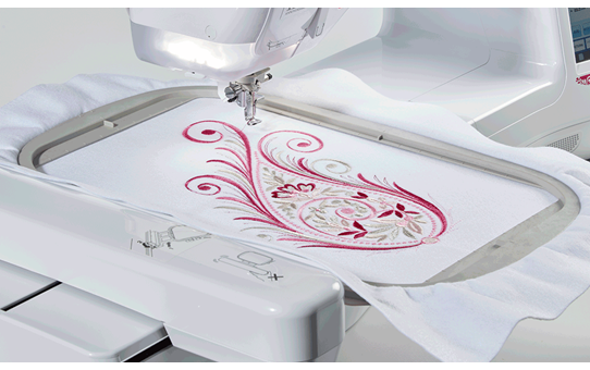 Brother Innov-is V3LE embroidering a decorative swirl design on white fabric