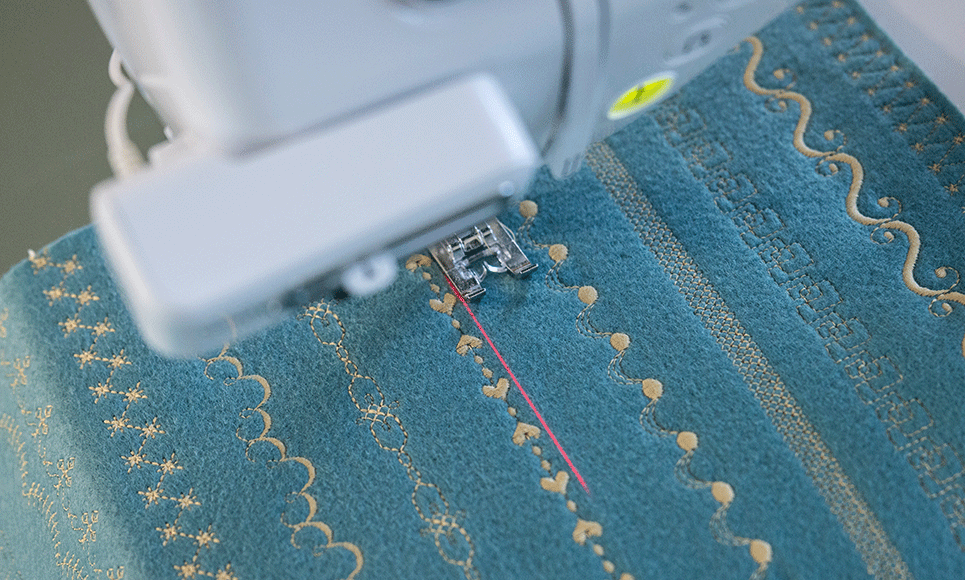 Brother BX1 laser guideline beside decorative stitching on blue fabric
