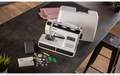Brother HF37 heavy duty sewing machine with hard case open and accessories laid out on a dark table