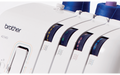 Close-up of the Brother 4234D overlocker showing colour-coded threading guides with four thread spools