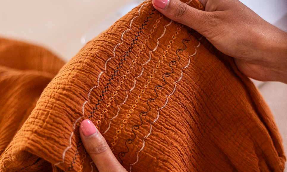 Decorative stitching on an orange garment