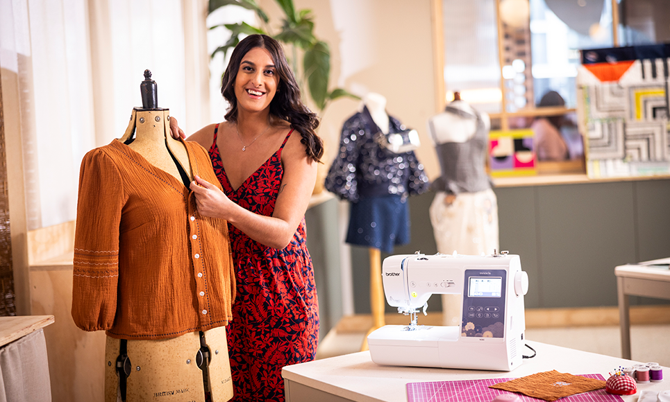 Brother Innov-is M380 beside a finished orange blouse on a dress form
